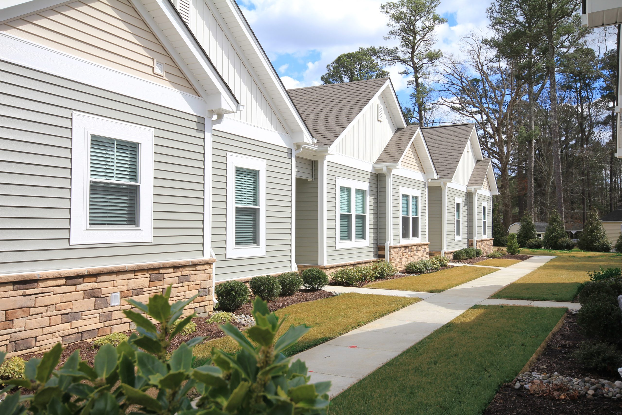 Exterior of Quad home Grey and white siding. Stone facade.